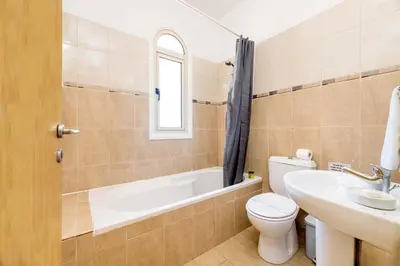 a bathroom with a toilet and a tub and a sink at Alex Villa Kapparis in Protaras