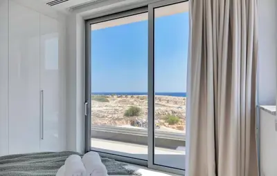 a bedroom with a window with a view of the ocean at Sea Pearl Seaview Villa - Oriana in Ayia Napa