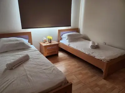 a bedroom with two beds and a night stand with two beds at Maestro III Apartment in Larnaka