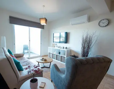 a living room with a couch and a table at Maestro III Apartment in Larnaka