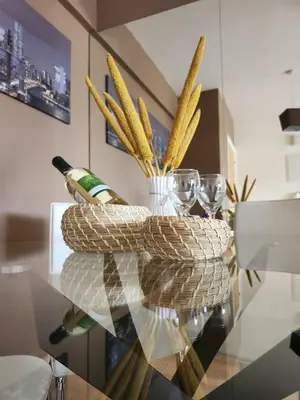 a glass table with wine bottles and glasses on it at Maestro III Apartment in Larnaka