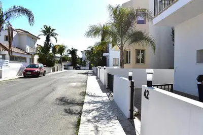 a car parked on the side of a street with palm trees at Palm Village Escape in Protaras