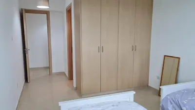a bedroom with a bed and wooden cabinets at The Olive Grove Escape, Eleonas Apts in Sotira