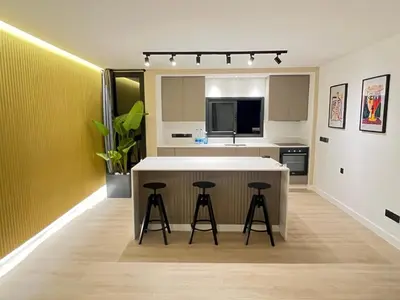 a kitchen with a white counter and stools in it at Modern 2bed in the centre in Nicosia