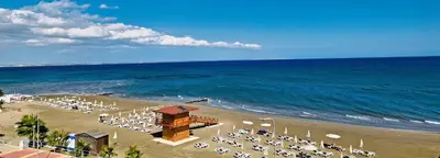 a beach with a bunch of chairs and the ocean at The Ciao Stelio Deluxe Boutique Hotel - Adults Only in Larnaka