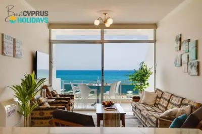 a living room with a view of the ocean at Makenzy Sandy Beachfront Paradise in Larnaka