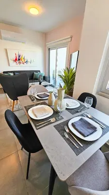 a dining room table with plates and glasses on it at Sealife Citycenter Residences in Larnaka