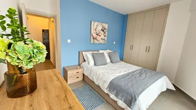 a bedroom with a bed and a blue wall at Sealife Citycenter Residences in Larnaka