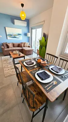 a dining room with a wooden table and chairs at Sealife Citycenter Residences in Larnaka
