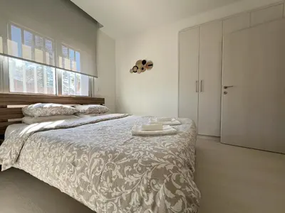a bedroom with a bed and a window and a door at Albert's Apartment Center 202B in Larnaka