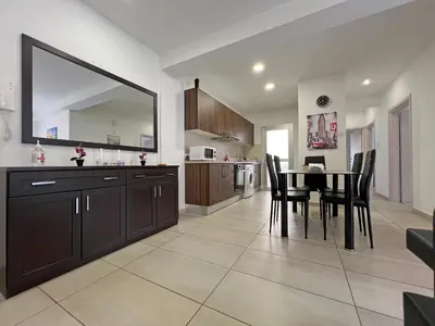 a kitchen and dining room with a table and chairs at Albert's Apartment Center 202B in Larnaka