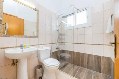 a bathroom with a toilet and a sink and a shower at Thekla Oasis Villa in Ayia Napa