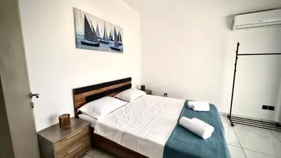 a bedroom with a bed and a picture of boats on the wall at 351 Turquoise Oasis in Limassol