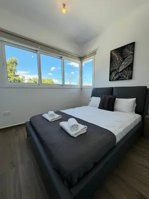 a bedroom with a large bed with two towels on it at Protaras Rustic Paradise Luxury Villa 1 in Paralimni