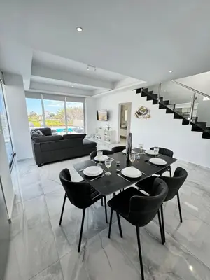 a dining room with a black table and chairs at Protaras Rustic Paradise Luxury Villa 1 in Paralimni