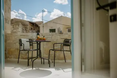 a table with chairs and fruit on a balcony at Smaragda's Guest Rooms in Limassol