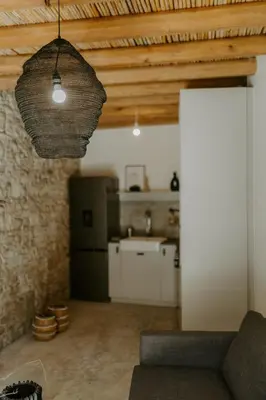 a living room with a couch and a kitchen at Smaragda's Guest Rooms in Limassol