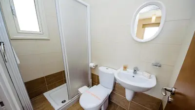 a bathroom with a toilet and a sink and a mirror at Kapparis Holiday Villa 018 in Protaras