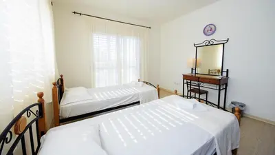 two beds in a room with a mirror and a table at Pernera Holiday Villa 015 in Protaras