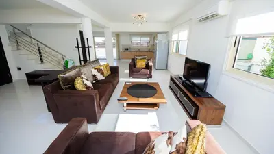 a living room with two couches and a tv at Pernera Holiday Villa 015 in Protaras