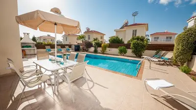 a patio with a table and chairs and a pool at Ayia Napa Holiday Villa 003 in Ayia Napa