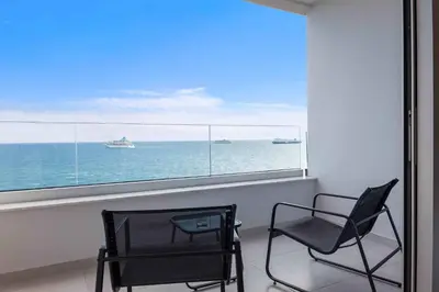 two chairs in front of a window with a view of the ocean at Phaedrus Living: Limassol Seaside Residences 01 in Limassol