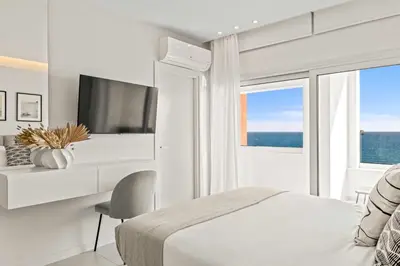 a white bedroom with a bed and a television at Phaedrus Living: Limassol Seaside Residences 02 in Limassol