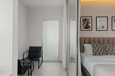 a bedroom with a mirror and a chair and a bed at Phaedrus Living: Limassol Seaside Residences 03 in Limassol