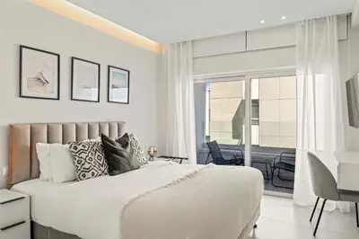 a bedroom with a bed and a desk and a balcony at Phaedrus Living Coastal Seaside Residences 04 in Limassol
