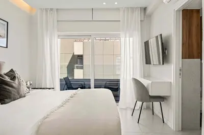 a bedroom with a bed and a desk and a window at Phaedrus Living Coastal Seaside Residences 04 in Limassol