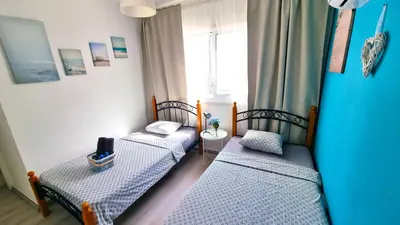 two twin beds in a room with a window at 2Br Apt Coastal Comfort with Internet Access in Larnaka
