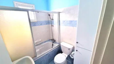 a bathroom with a shower and a toilet and a tub at 2Br Apt Coastal Comfort with Internet Access in Larnaka