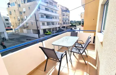 a balcony with a table and chairs on a balcony at 2Br Apt Coastal Comfort with Internet Access in Larnaka