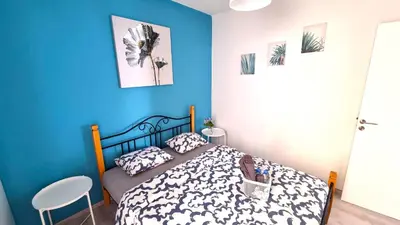 a bedroom with a bed and a blue wall at 2Br Apt Coastal Comfort with Internet Access in Larnaka