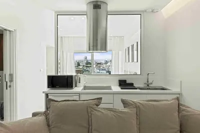 a living room with a couch and a kitchen with a window at Phaedrus Living Limassol Seaside Residences 06 in Limassol