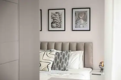 a bedroom with a bed with three pictures on the wall at Phaedrus Living Limassol Seaside Residences 06 in Limassol