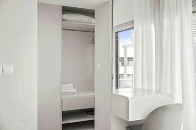 a white bathroom with a sink and a mirror at Phaedrus Living Limassol Seaside Residences 06 in Limassol