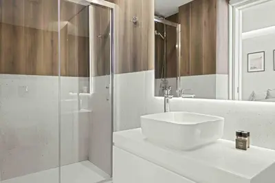 a white bathroom with a sink and a shower at Phaedrus Living Limassol Seaside Residences 06 in Limassol