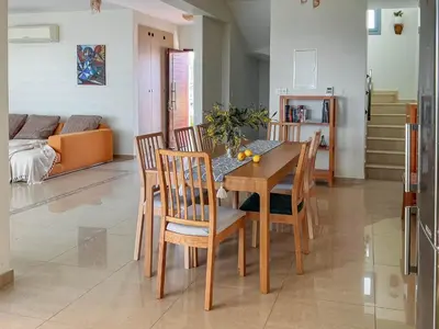 a kitchen and dining room with a wooden table and chairs at Villa Marina in Ayia Thekla with Heated Pool in Ayia Napa
