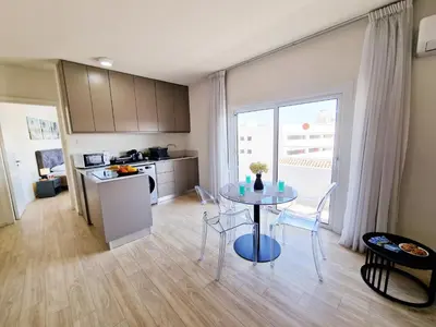 a kitchen and dining room with a table in a room at Kitieos Central Apartment with Sea View in Larnaka