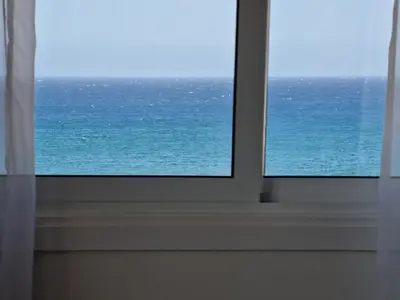 a window with a view of the ocean at Kitieos Central Apartment with Sea View in Larnaka
