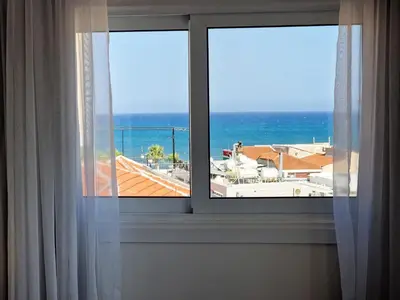 a window with a view of the ocean at Kitieos Central Apartment with Sea View in Larnaka