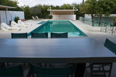 a table and chairs in front of a swimming pool at The Olive Tree in Protaras