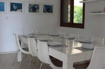 a white dining room with a white table and white chairs at The Olive Tree in Protaras