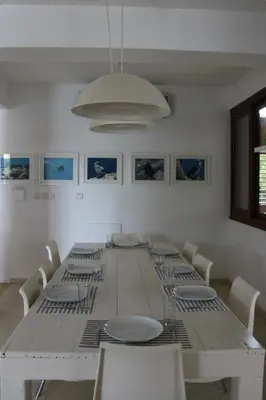 a white dining room with a white table and chairs at The Olive Tree in Protaras