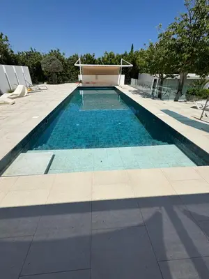 a swimming pool with blue tiles on the ground at The Olive Tree in Protaras
