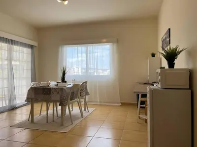 a kitchen and dining room with a table and a refrigerator at STUDIO in Limassol