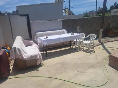 a couple of beds sitting on a patio with a hose at Room with private entrance from outside, traditional house in Livadhia