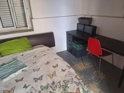 a bedroom with a bed and a desk and a red chair at Room with private entrance from outside, traditional house in Livadhia