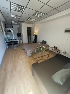 a living room with two beds and a table at LivePro in Larnaka